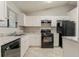 Well-lit kitchen featuring white cabinets, granite counters, and modern black appliances at 4905 Sandberg Ct, Stone Mountain, GA 30088