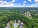 Overhead view of a suburban neighborhood encircled by dense forest, showcasing the serene environment at 6160 Overleaf Ter, Cumming, GA 30040