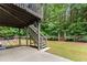 Backyard showcasing a patio area with stairs leading to the upper deck and an arched gate at 6160 Overleaf Ter, Cumming, GA 30040