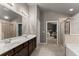 Elegant bathroom with a double vanity, glass shower, and large mirror at 6160 Overleaf Ter, Cumming, GA 30040
