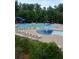 Inviting community pool area with water slide, splash pad, lounge chairs and umbrella-covered tables at 6160 Overleaf Ter, Cumming, GA 30040