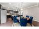 Bright dining area with a wooden table, blue upholstered chairs, and pendant lighting overlooking the kitchen at 6160 Overleaf Ter, Cumming, GA 30040