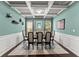 Dining room featuring coffered ceiling, wainscoting, and a modern chandelier at 6160 Overleaf Ter, Cumming, GA 30040