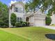 Two-story home boasts manicured lawn, complementing mature trees and well-kept landscaping at 6160 Overleaf Ter, Cumming, GA 30040