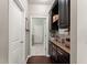 Hallway with dark wood floors, built-in shelves and cabinets, and white doors leading to the laundry room at 6160 Overleaf Ter, Cumming, GA 30040