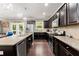 Modern kitchen featuring granite counters, stainless steel appliances, dark cabinets, and a view of the backyard at 6160 Overleaf Ter, Cumming, GA 30040
