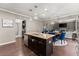 Open-concept kitchen featuring a center island, granite countertops, stainless steel appliances, and dark wood cabinets at 6160 Overleaf Ter, Cumming, GA 30040