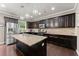 Spacious kitchen with a center island, granite countertops, stainless steel appliances, and dark wood cabinets at 6160 Overleaf Ter, Cumming, GA 30040