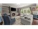 Inviting living room with a fireplace, built-in shelves, and large windows at 6160 Overleaf Ter, Cumming, GA 30040