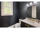 Stylish powder room with navy textured walls, modern fixtures, and a marble countertop at 148 Canton St, Alpharetta, GA 30009