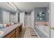 Well-lit bathroom featuring a soaking tub, separate shower, vanity, and decorative wall art at 345 Jesse Martin Trl, Canton, GA 30115