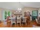 Well-lit dining room featuring a stone fireplace, chandelier, and rustic hardwood floors at 345 Jesse Martin Trl, Canton, GA 30115