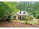 Quaint home with a metal roof, cozy front porch, and lots of mature trees at 345 Jesse Martin Trl, Canton, GA 30115