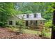 Charming cottage-style home featuring a metal roof and a covered front porch, nestled among mature trees at 345 Jesse Martin Trl, Canton, GA 30115