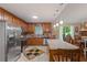 Kitchen area with stainless appliances, island with seating, and view to dining area with fireplace at 345 Jesse Martin Trl, Canton, GA 30115
