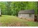 Backyard shed with a lawn mower, small windows, and plenty of storage in a large yard at 345 Jesse Martin Trl, Canton, GA 30115