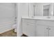 Bright bathroom with double vanity, white cabinets, and wood-look flooring at 3455 Jasmine Sw Way, Atlanta, GA 30331