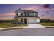 Well-lit exterior view of a two-story home at dusk with a manicured lawn and dark window shutters at 3455 Jasmine Sw Way, Atlanta, GA 30331