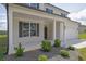 Charming covered front porch with white columns, dark shutters, and landscaped flower beds at 3455 Jasmine Sw Way, Atlanta, GA 30331