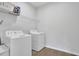Laundry room with white washer and dryer and white wire rack shelving at 3455 Jasmine Sw Way, Atlanta, GA 30331
