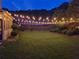 Backyard featuring a lush lawn, garden beds, charming string lights, and private fence at 3975 Silverthorn Trce, Cumming, GA 30028