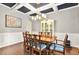 Elegant dining room featuring coffered ceilings, wainscoting, and a stylish light fixture at 3975 Silverthorn Trce, Cumming, GA 30028