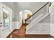 Elegant entryway featuring hardwood floors, a staircase with iron spindles, and a view into adjacent rooms at 3975 Silverthorn Trce, Cumming, GA 30028