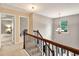 Upstairs hallway with a view of a decorative chandelier with beautiful stairway and natural light at 3975 Silverthorn Trce, Cumming, GA 30028