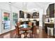 Stylish eat-in kitchen with stainless steel appliances, kitchen island, and glass table set for four at 3975 Silverthorn Trce, Cumming, GA 30028