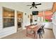 A sunroom with a ceiling fan, TV, windows with blinds, and a table for dining or entertaining at 3975 Silverthorn Trce, Cumming, GA 30028