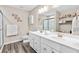 Bright bathroom featuring a double sink vanity, gray wood-look flooring, and decorative wall art at 6065 Crescent Landing Dr, Cumming, GA 30028