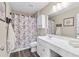 Bathroom with white vanity, wood-look flooring, and a floral-themed shower curtain at 6065 Crescent Landing Dr, Cumming, GA 30028