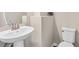 Bright, modern bathroom features a pedestal sink and sleek toilet at 6065 Crescent Landing Dr, Cumming, GA 30028