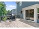View of deck with grill and glass sliding doors overlooking the backyard and lush greenery at 6065 Crescent Landing Dr, Cumming, GA 30028