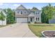 Charming two-story home featuring a two-car garage, landscaped yard, and modern architectural details at 6065 Crescent Landing Dr, Cumming, GA 30028