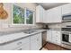 Updated kitchen with stainless appliances, light granite counters, and bright white cabinets with a view at 6065 Crescent Landing Dr, Cumming, GA 30028