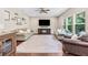 Comfortable living room with fireplace, ceiling fan, and large windows providing natural light at 6065 Crescent Landing Dr, Cumming, GA 30028