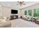 Bright living room featuring a fireplace, ceiling fan and lots of natural light at 6065 Crescent Landing Dr, Cumming, GA 30028