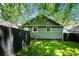 Private backyard with lush green lawn, a dark wood fence, and mature trees at 905 Gaston Sw St, Atlanta, GA 30310
