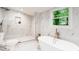 Contemporary bathroom featuring a glass enclosed shower, soaking tub, and sleek fixtures at 905 Gaston Sw St, Atlanta, GA 30310
