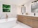 Bright bathroom with white marble tile, double sink vanity, and free standing soaking tub at 905 Gaston Sw St, Atlanta, GA 30310