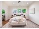 Bright bedroom featuring hardwood floors, decorative pillows and a cozy bench with a green view at 905 Gaston Sw St, Atlanta, GA 30310