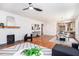 Bright living room features a painted fireplace, ceiling fan and hardwood floors flowing into the kitchen and dining room at 905 Gaston Sw St, Atlanta, GA 30310
