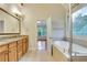 Bright bathroom with a soaking tub, decorative window, and a double sink vanity at 26 Trillium Ln, Acworth, GA 30101