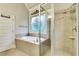 Modern bathroom showcasing a glass-enclosed shower and soaking tub beneath a decorative window at 26 Trillium Ln, Acworth, GA 30101