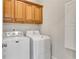 Bright laundry room with side-by-side washer and dryer and wooden cabinets at 26 Trillium Ln, Acworth, GA 30101