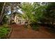 Exterior view of a home with a deck and landscaped backyard, complemented by lush greenery and mature trees at 540 Shale Ct, Alpharetta, GA 30022