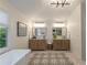 Bright bathroom featuring dual sinks, modern lighting, and a sleek, patterned tile floor at 540 Shale Ct, Alpharetta, GA 30022