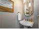 Stylish powder room with a pedestal sink, decorative mirror, elegant lighting, and eye-catching wall tile at 540 Shale Ct, Alpharetta, GA 30022