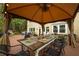 Spacious outdoor dining area under a gazebo, features a long table set for a meal, overlooking a beautiful backyard at 540 Shale Ct, Alpharetta, GA 30022